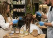 Deux stylistes appliquent une coloration cheveux naturelle écologique sur des cheveux mouillés, à l’aide de brosses.